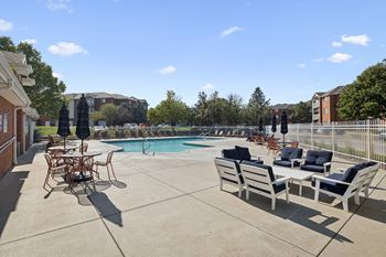 A pool area with chairs and a table.